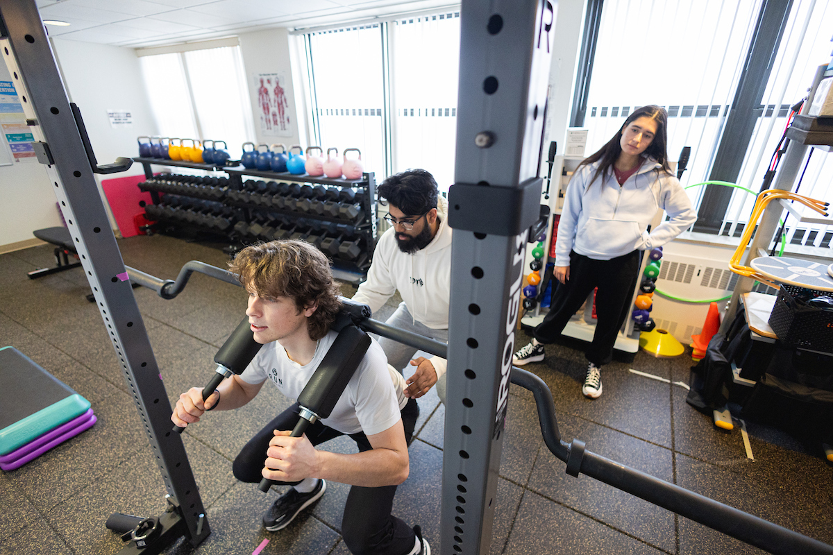 Students in the Exercise Science MS program practice skills in a gym.