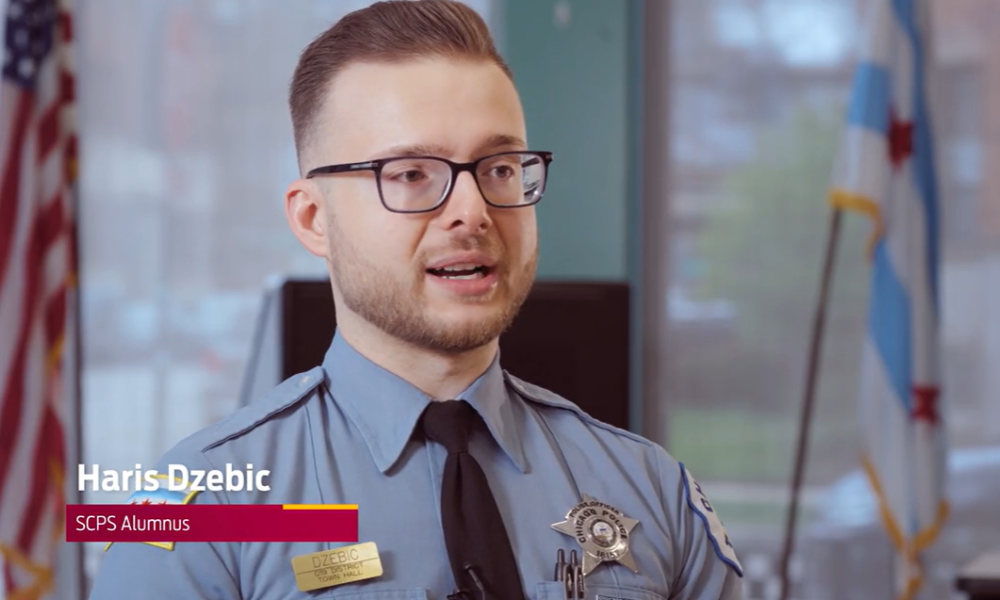 A man in a police uniform speaks to the camera